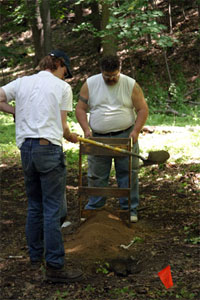 Jim waits for a shovel full of dirt from Evan up at the East Bank House